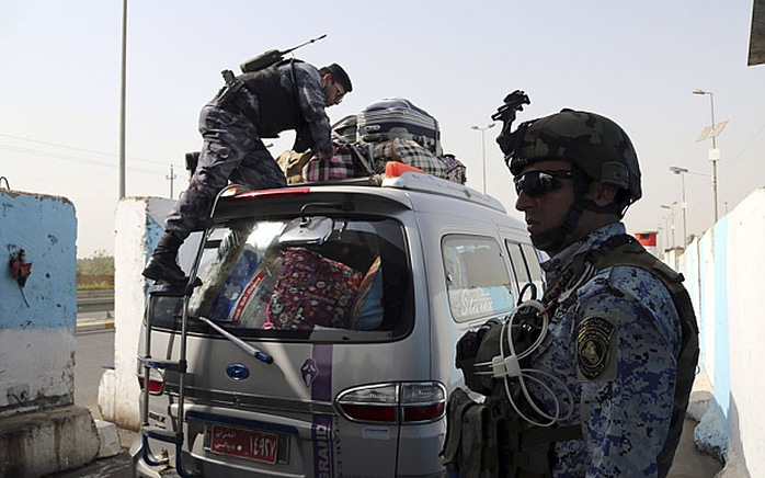 Cảnh sát Iraq đang kiểm tra một chiếc xe tiến vào thủ đô Baghdad. Ảnh: AP