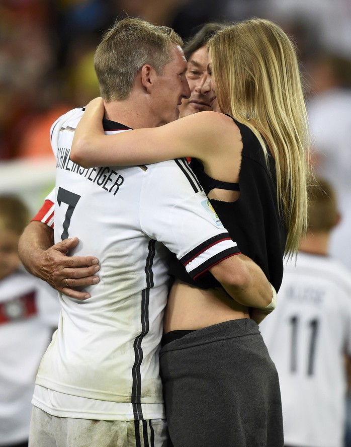 Bastian Schweinsteiger chia vui với bạn gái và HLV Loew (ảnh dưới) sau trận