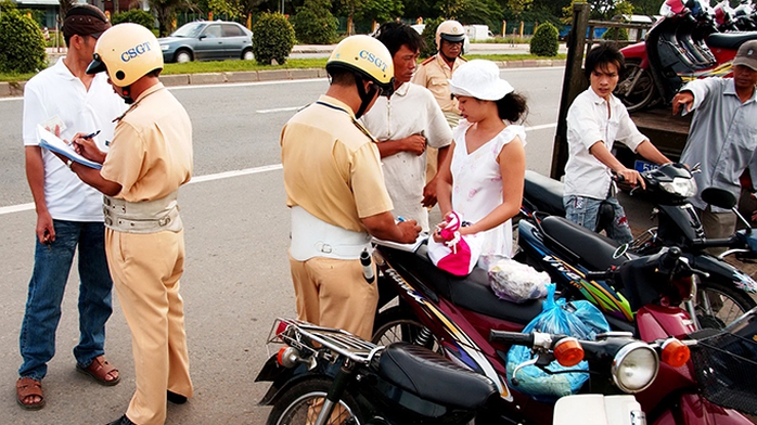 CSGT xử phạt những người đi xe máy không đội mũ bảo hiểm trên đường xuyên Á, Q.12, TP.HCM - Ảnh: N.C.T.