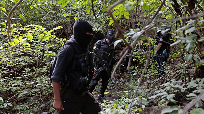Cảnh sát Mexico đang bảo vệ khu mộ tập thể. Ảnh: Reuters