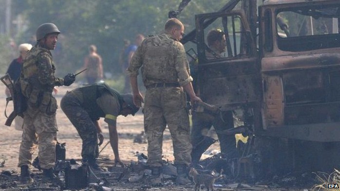 Xe của quân đội Ukraine cháy đen do trúng pháo kích của phe ly khai. Ảnh: EPA