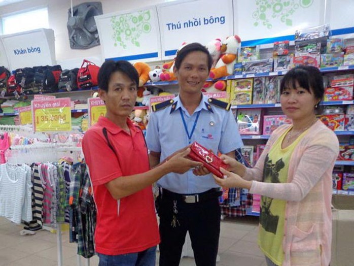 Anh Phan Hoàng Việt (áo đỏ) và đại diện tổ bảo vệ siêu thị trả lại tiền đánh rơi cho khách hàng vào chiều ngày 4-6.