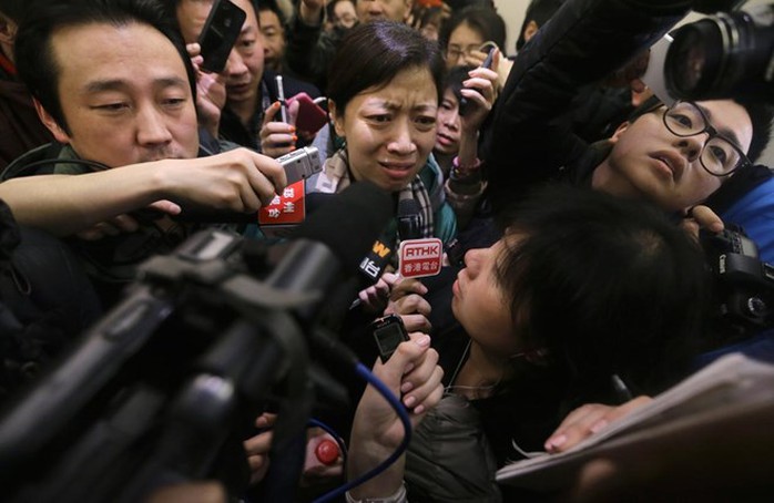 Cánh phóng viên quây lấy một thân nhân của hành khách trên máy bay mất tích (Nguồn: AFP)