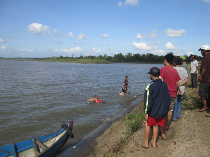 Người dân đưa thi thể nạn nhân lên bờ. Ảnh Thúy An