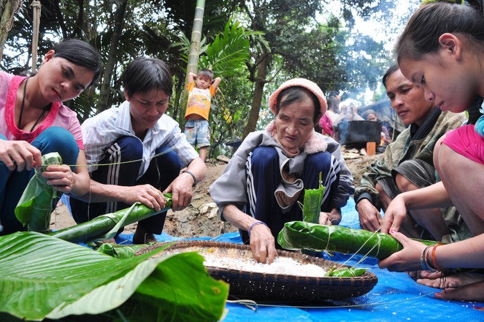 Hai cha con “người rừng” (giữa) cùng gói bánh lá dong đón Tết cổ truyền