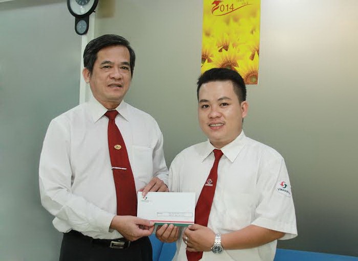 Ông Huỳnh Văn Sỹ, Phó tổng giám đốc Vinasun (bìa trái), tặng tiền thưởng cho tài xế Nguyễn Tuấn Quốc