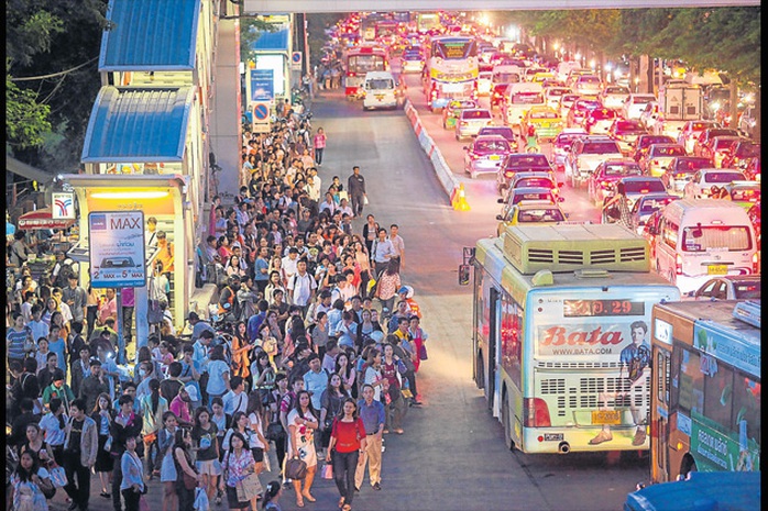 Người dân xếp hàng chờ xe buýt gần công viên Chatuchak ở Bangkok để về nhà trước giờ giới nghiêm tối 22-5. Ảnh: Bangkok Post