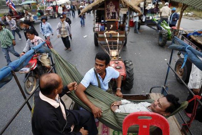 Nông dân Thái Lan nghỉ ngơi trên đường cao tốc ở Ayutthaya ngày 21-2. Ảnh: Reuters