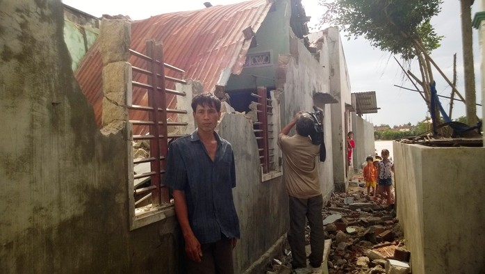 Người đàn ông này thẫn thờ trước ngôi nhà bị tốc mái, sập tường sau khi bão đi qua