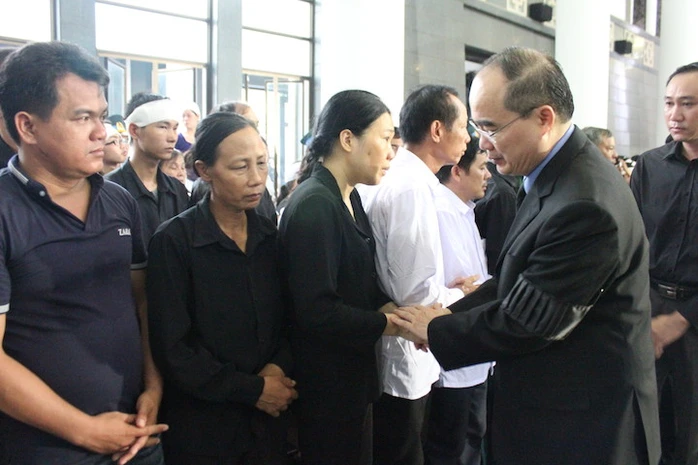 Chủ tịch UB Mặt trận tổ quốc Việt Nam Nguyễn Thiện Nhân nắm chặt tay động viên thân nhân cán bộ, chiến sỹ hy sinh