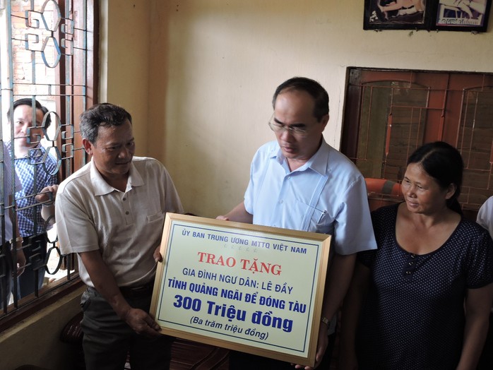 Ông Nguyễn Thiện Nhân, Chủ tịch UBTU7MTTQ Việt Nam (giữa), trao tiền hỗ trợ cho gia đình ngư dân Lê Đầy