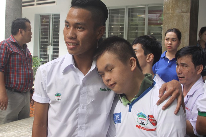  Hậu vệ Lê Văn Sơn trò chuyện với một trẻ khuyết tật