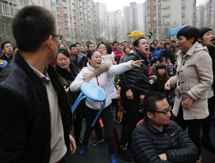 Phụ huynh bức xúc trước cổng trường. Ảnh: China Daily