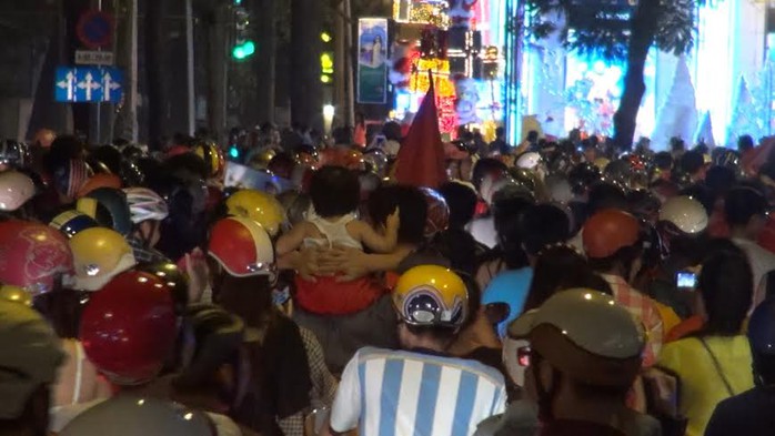Dòng người tràn ra đường, có người còn cõng trẻ em để ăn mừng chiến thắng của đội tuyển Việt Nam