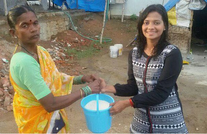 Nhà báo Manju Latha Kalanidihi trao xô gạo cho người cần giúp đỡ. Ảnh: Facebook Ice Bucket Challenge
