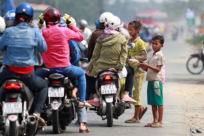 Mỗi khi đèn tín hiệu giao thông chuyển sang đỏ, những đứa trẻ lại lao ra trước đầu xe xin tiền.