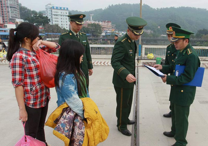 Cảnh sát Trung Quốc đang bàn giao 2 phụ nữ cho cảnh sát Việt Nam. Ảnh: CFP