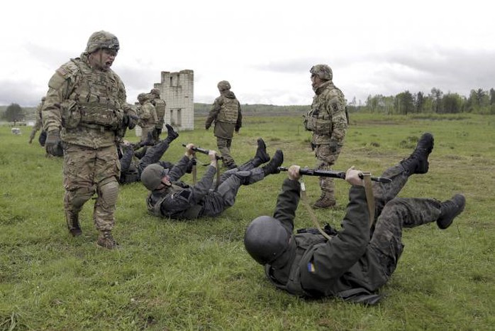 Thành viên Lữ đoàn Dù 173 của Mỹ (đứng( đang huấn luyện binh sĩ Ukraine. Ảnh: Reuters