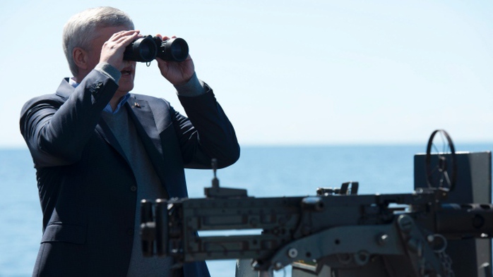 Thủ tướng Canada Stephen Harper dùng ống nhòm theo dõi 2 tàu khu trục Nga. Ảnh: Canadian Press