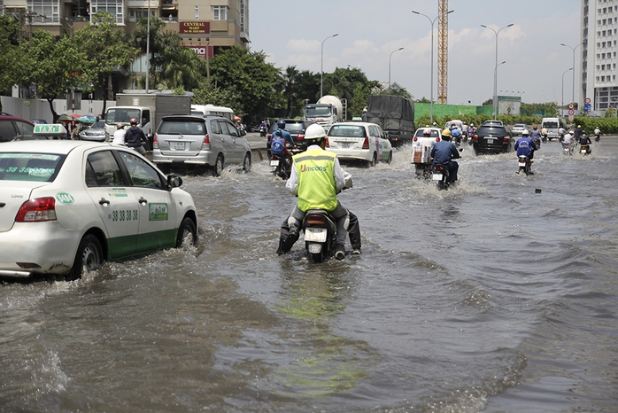 Nước ngập hơn nửa bánh xe khiến các phương tiện di chuyển gặp nhiều khó khăn.