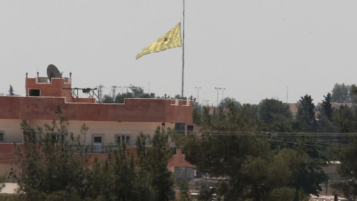 Lá cờ của YPG cắm gần biên giới Syria - Thổ Nhĩ Kỳ. Lực lượng này mới phát hiện 400 m đường hầm do IS đào tại biên giới hai nước. Ảnh: AP