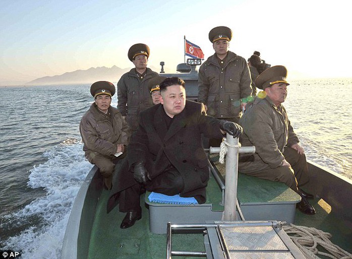 Maximum alert: Pictured on a boat near the western sea border with South Korea, Kim urged front-line troops to be on maximum alert for a potential war in March 2013