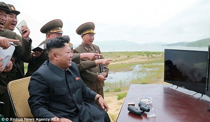 Missile testing fun: Kim smiles along with excited officials as they watch missile tests in North Korea