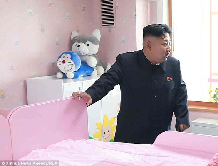 Photobomb: Kim was oblivious to the pair of cuddly toys placed in a compromising position on a wardrobe behind him as he visited an orphanage in Pyongyang in October last year
