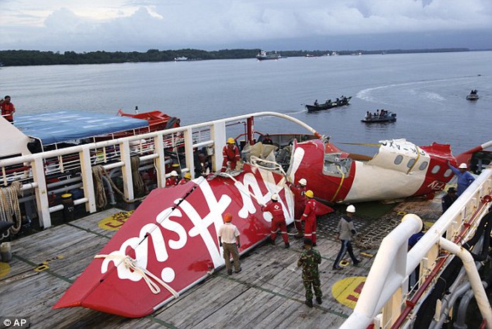 Crew members of the Crest Onyx ship untie parts of the tail section of AirAsia Flight OZ8501 at Kumai port in Pangkalan Bun, Indonesia