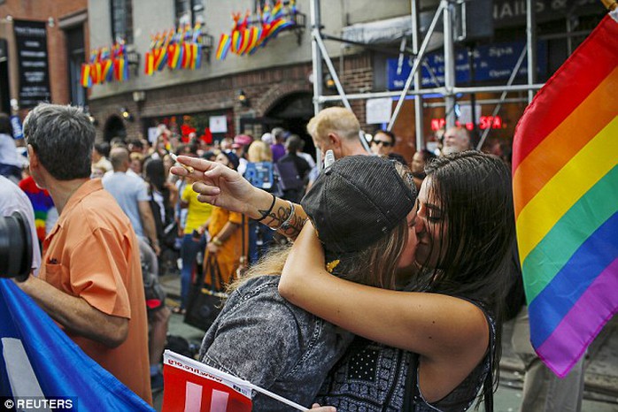 Big day: Women kiss each other as people celebrate outside the Stonewall Inn in New York City