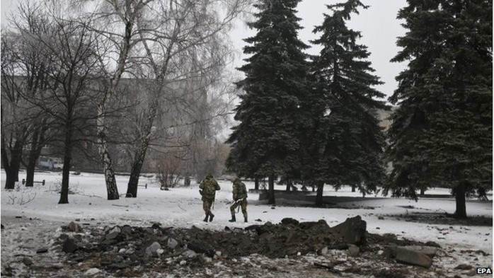 Ukrainian servicemen pass the crater of a shell in the city centre of Debaltseve, 22 January 2015