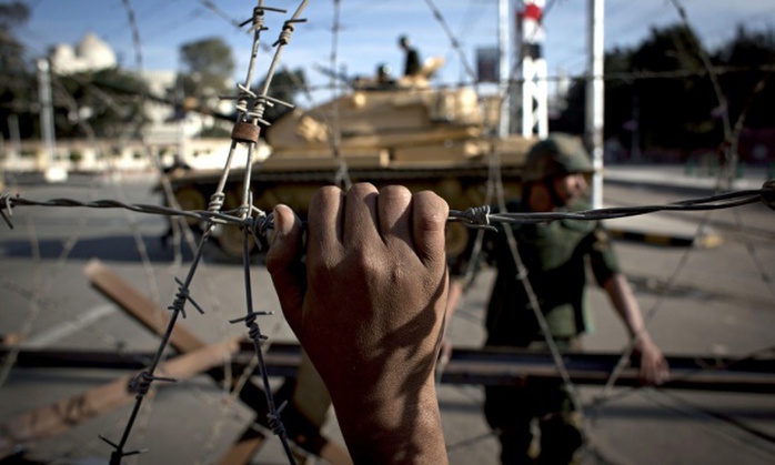 An Egyptian army tank is seen behind barbed wire. 