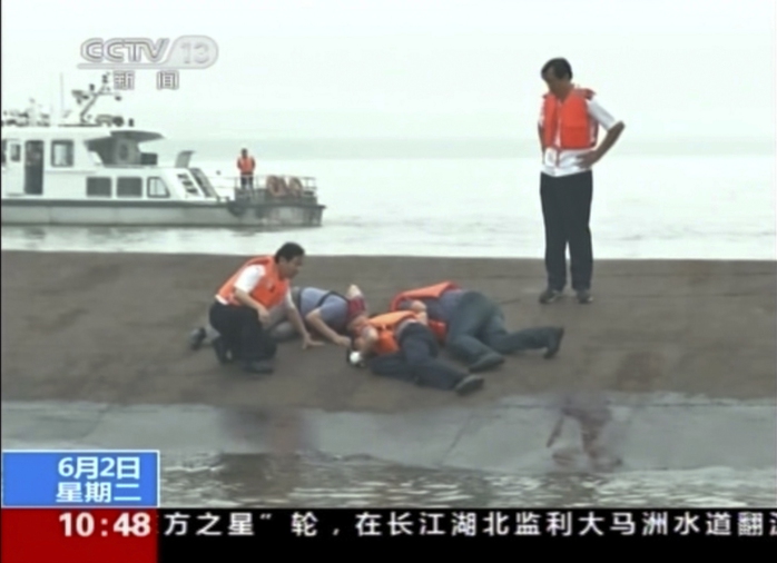 In this image taken from video released by Chinas CCTV, rescue workers listen for a response to their tapping on the hull of a capsized ship on...