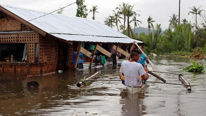 Người dân tại thị trấn Palo, tỉnh Samar, Philippines chống trọi với lũ lụt. Ảnh Reuters