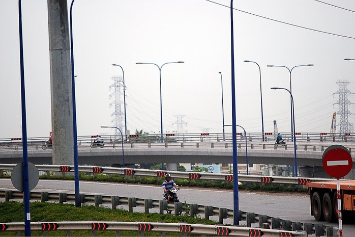 Một người điều khiển xe máy di chuyển từ cầu vượt Cát Lái qua đường Mai Chí Thọ