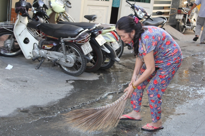 Người dân thu dọn nước thải từ chung cư 127 Đinh Tiên Hoàng&nbsp;