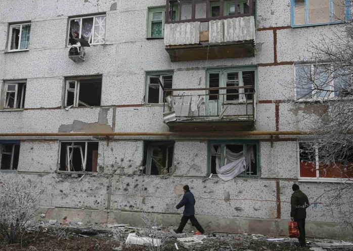 Cư dân Svitlodarsk ở miền Đông Ukraine bên ngoài những tòa nhà tan hoang. Ảnh: Reuters