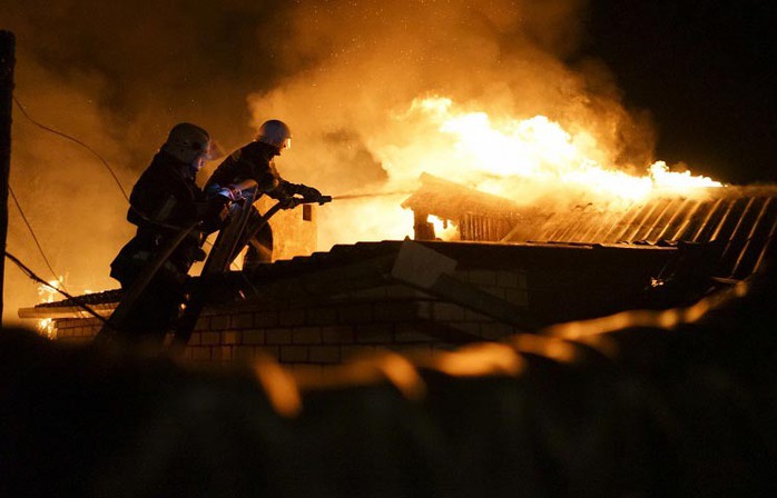 Nhân viên cứu hỏa chữa cháy tại một ngôi nhà bị pháo kích ở Donetsk, miền Đông Ukraine Ảnh: AP