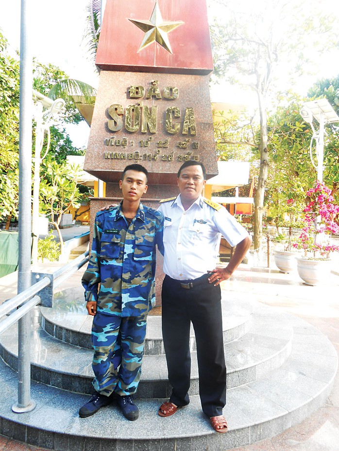 Thượng tá Mai Xuân Tuyên và con trai Mai Minh Chiến bên cột mốc chủ quyền trên đảo Sơn Ca, quần đảo Trường Sa. (Ảnh do nhân vật cung cấp) Ảnh: NGUYỄN Á