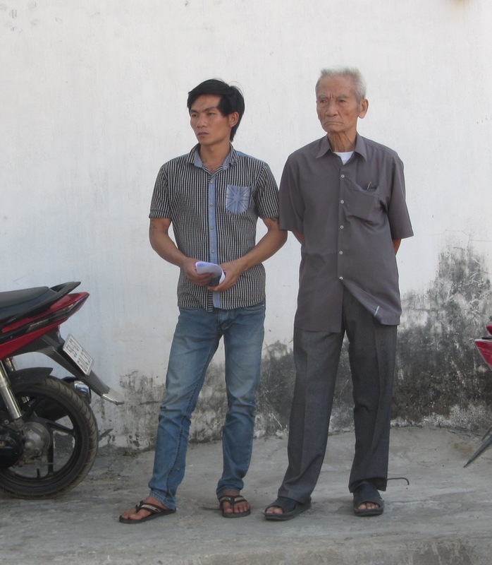 Ông Truyện (bên phải) và con của bị can Huỳnh Văn Nén lặng người khi nhận thư trả lời không chấp nhận cho tại ngoại của cơ quan CSĐT.