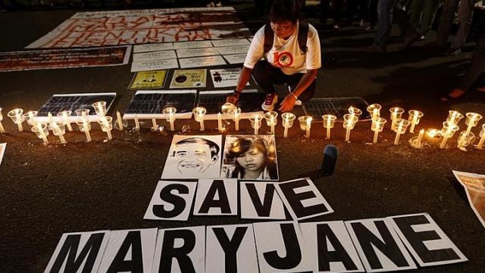 Một người di cư Indonesia thắp nến kêu gọi cứu bà Mary Jane Veloso. Ảnh: EPA