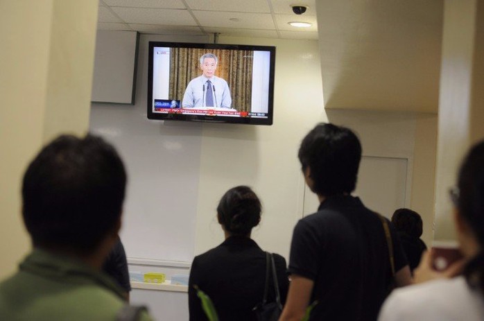 Người dân Singapore theo dõi Thủ tướng Lý Hiển Long phát biểu trực tiếp. Ảnh: Straits Times