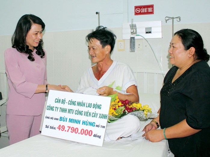 Chủ tịch LĐLĐ TP HCM, bà Nguyễn Thị Thu (trái), thăm công nhân được mổ tim Ảnh: THANH NGA