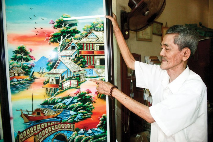 Nghệ nhân Trương Cung Thơ và một bức tranh kiếng vừa hoàn thiện Ảnh: KHÁNH AN