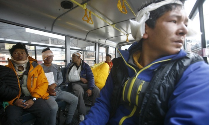 Các hướng dẫn viên du lịch ở Everest đang được chuyển bằng xe buýt đến nơi an toàn. Ảnh: AP