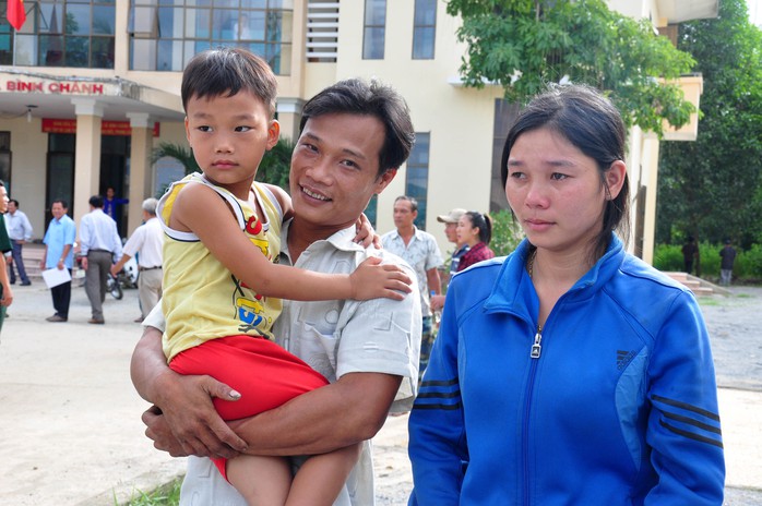 Ngư dân Nguyễn Phú Cầu ôm chặt đứa con trai 5 tuổi vào lòng. Ảnh: Tử Trực