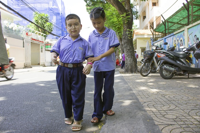 Huỳnh Giao dắt tay một người bạn khuyết tật sau giờ tan học