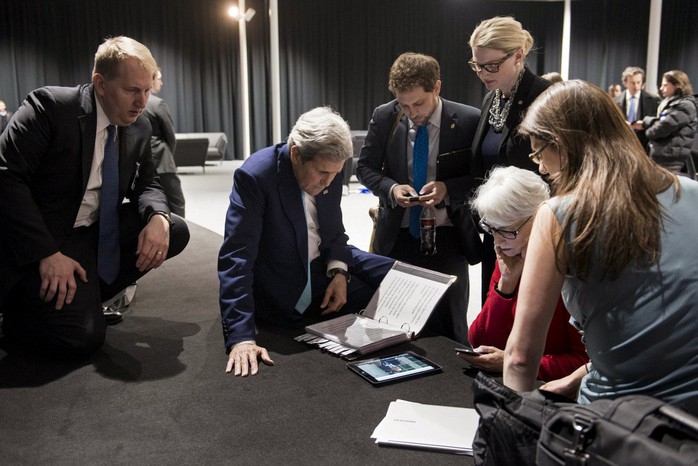 Ngoại trưởng Mỹ John Kerry (giữa) cùng phái đoàn Mỹ theo dõi Tổng thống Barack Obama phát biểu về thỏa thuận hạt nhân Iran qua máy tính bảng. Ảnh: Reuters