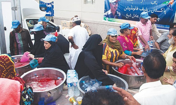 Các tình nguyện viên phát nước cho những người say nắng ở TP Karachi. Ảnh: AP