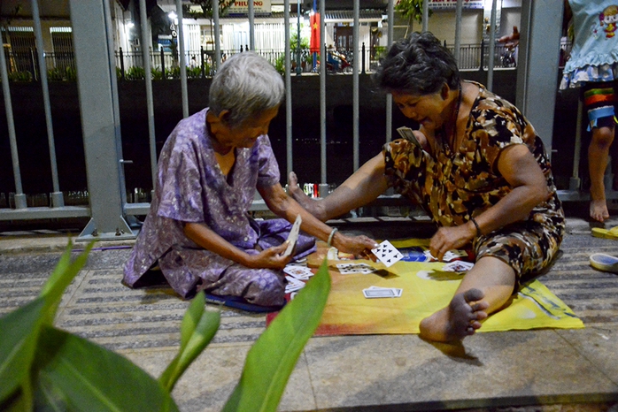 Hai cụ bà vô tư ngồi chơi đánh bài.